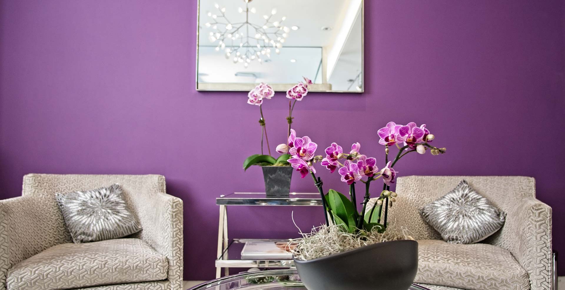 Maurice M. Khosh, MD, FACS office lobby. Purple walls, mirror, an orchid on a beautiful table.