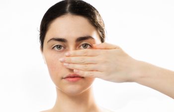 Woman covering her nose with her hand.