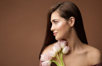 attractive brunette holds a bouquet of pink tulips