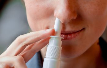 Medicine nose, nasal spray or drops for health in white bottle, container in hand or palm from cold, flu, illness. Liquid pharmacy, care or treatment. Medical object, drug.